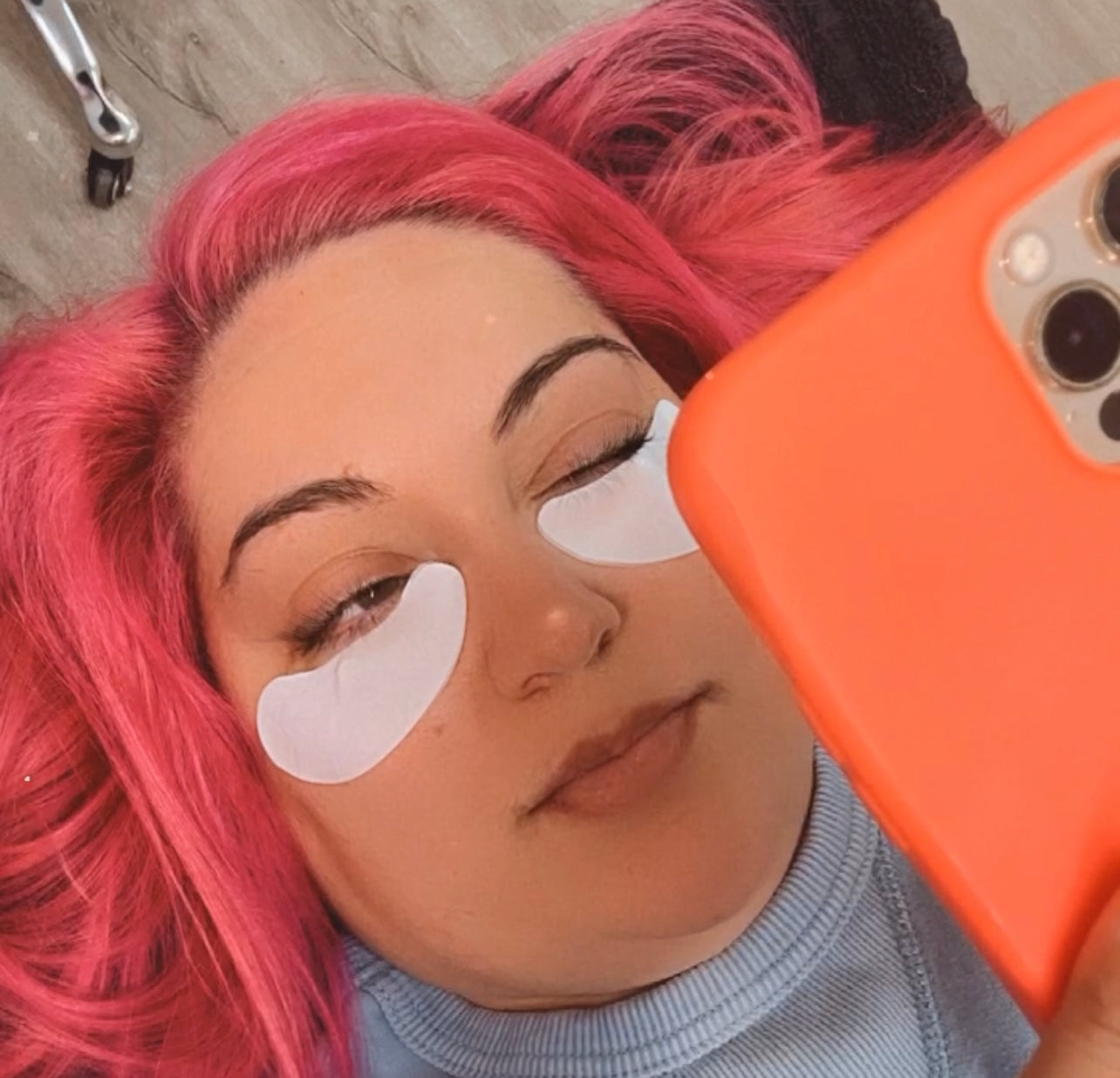 Girl with eyes slightly open while wearing under eye pads
